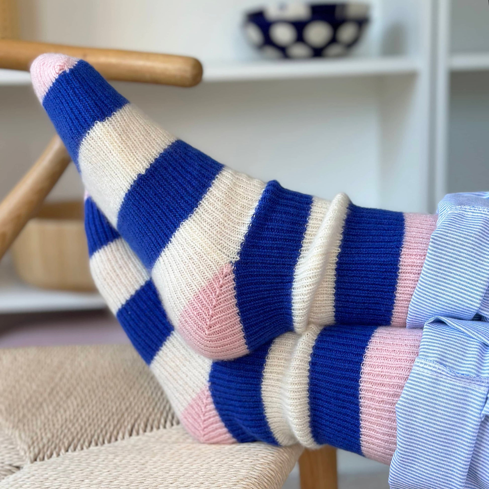 100% cashmere socks.  Handmade socks with chunky blue and cream stripes and pink heel and toe.  Chunky fun cashmere socks on feet with legs crossed.