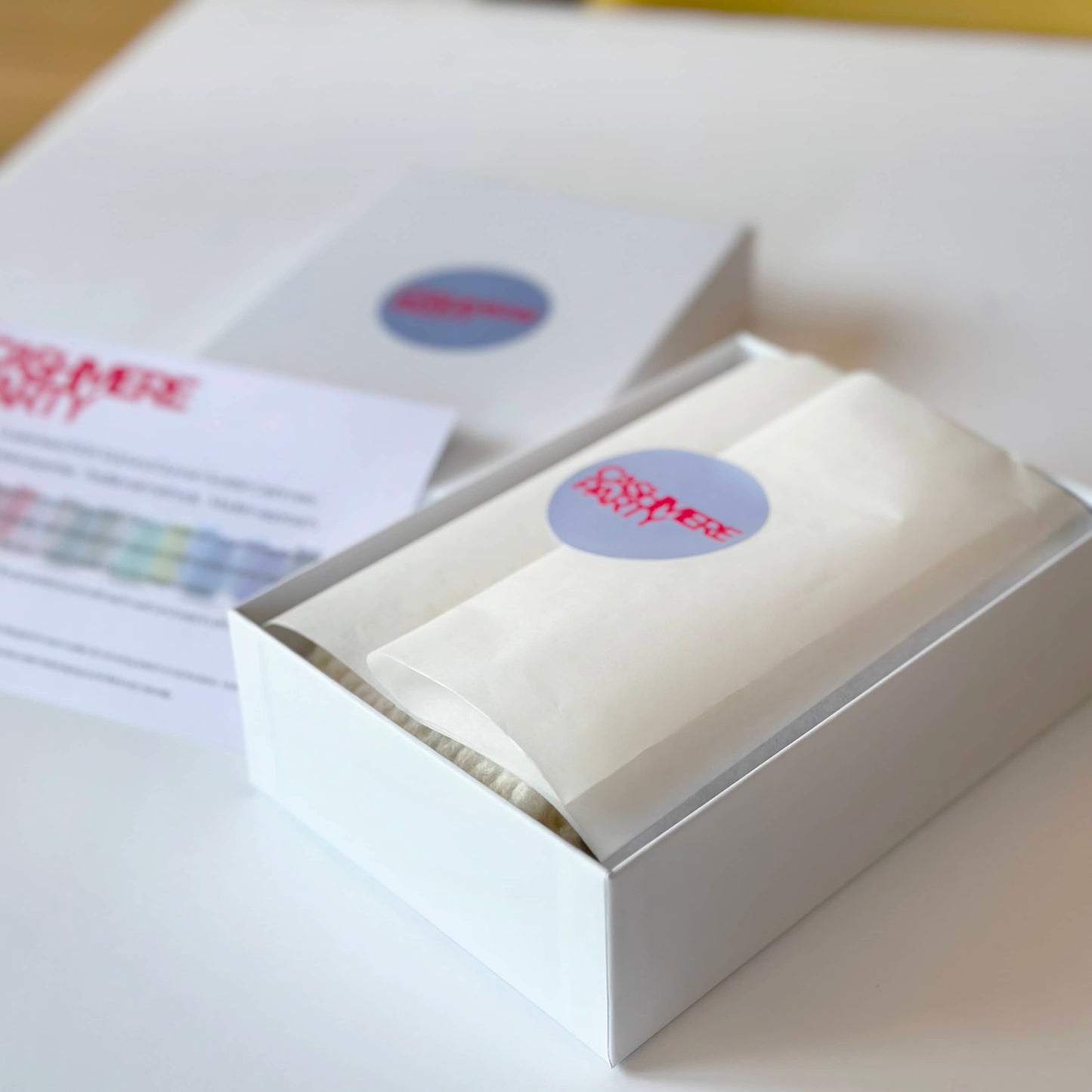 Gift box for 100% cashmere socks by Cashmere Party. Handmade socks wrapped in tissue with a branded sticker.
