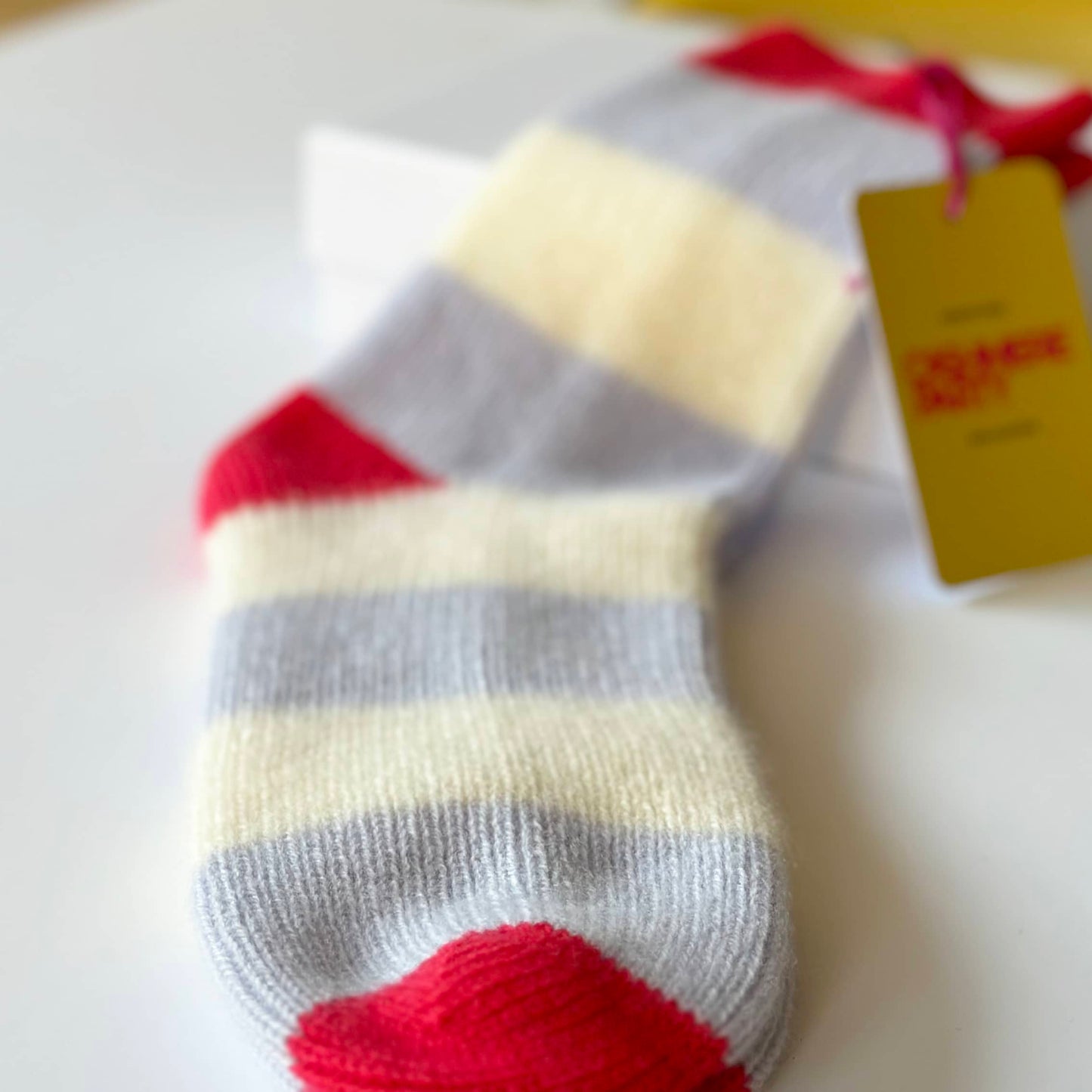 Close up of 100% cashmere socks by Cashmere Party. Bold modern socks with stripes in Light Blue, Cream and Red.