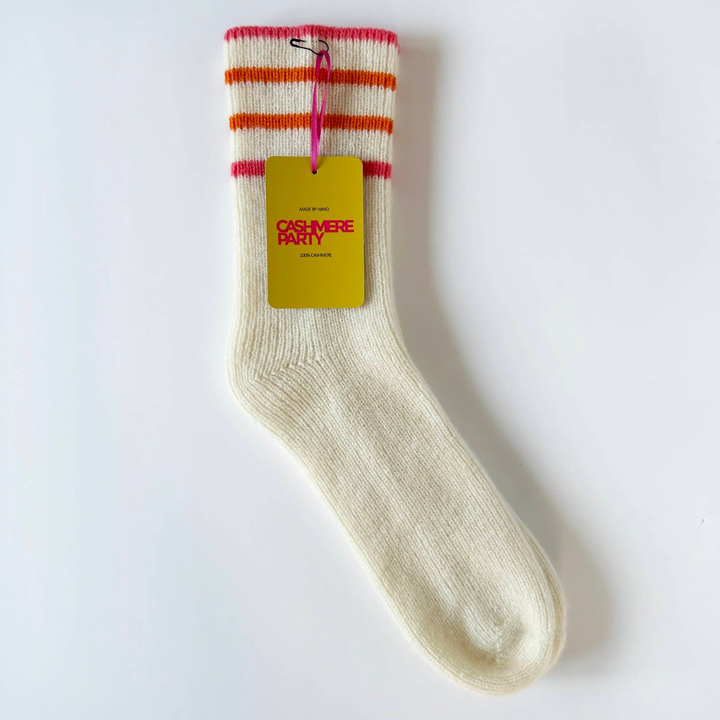 Flat image of 100% cashmere sport socks by Cashmere Party.  Handmade cashmere sports socks with coral and orange sport stripes.  Cashmere Party swing ticket.