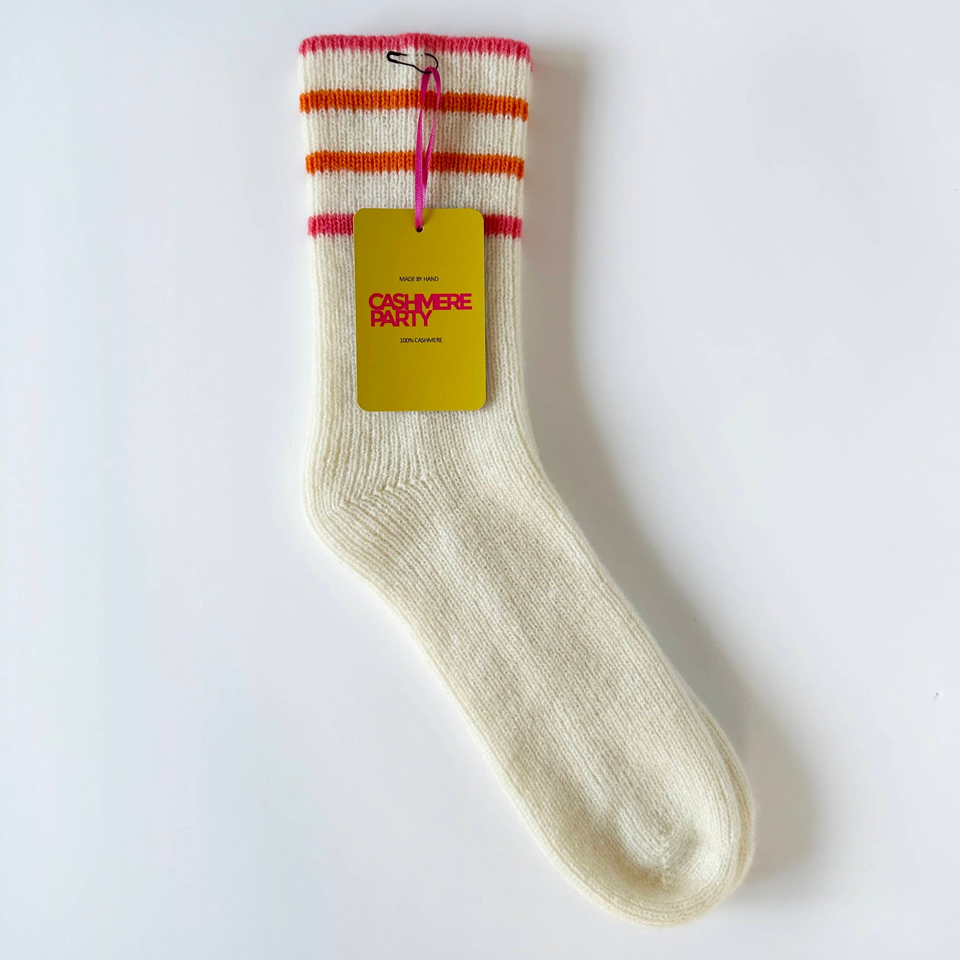 Flat image of 100% cashmere sport socks by Cashmere Party.  Handmade cashmere sports socks with coral and orange sport stripes.  Cashmere Party swing ticket.