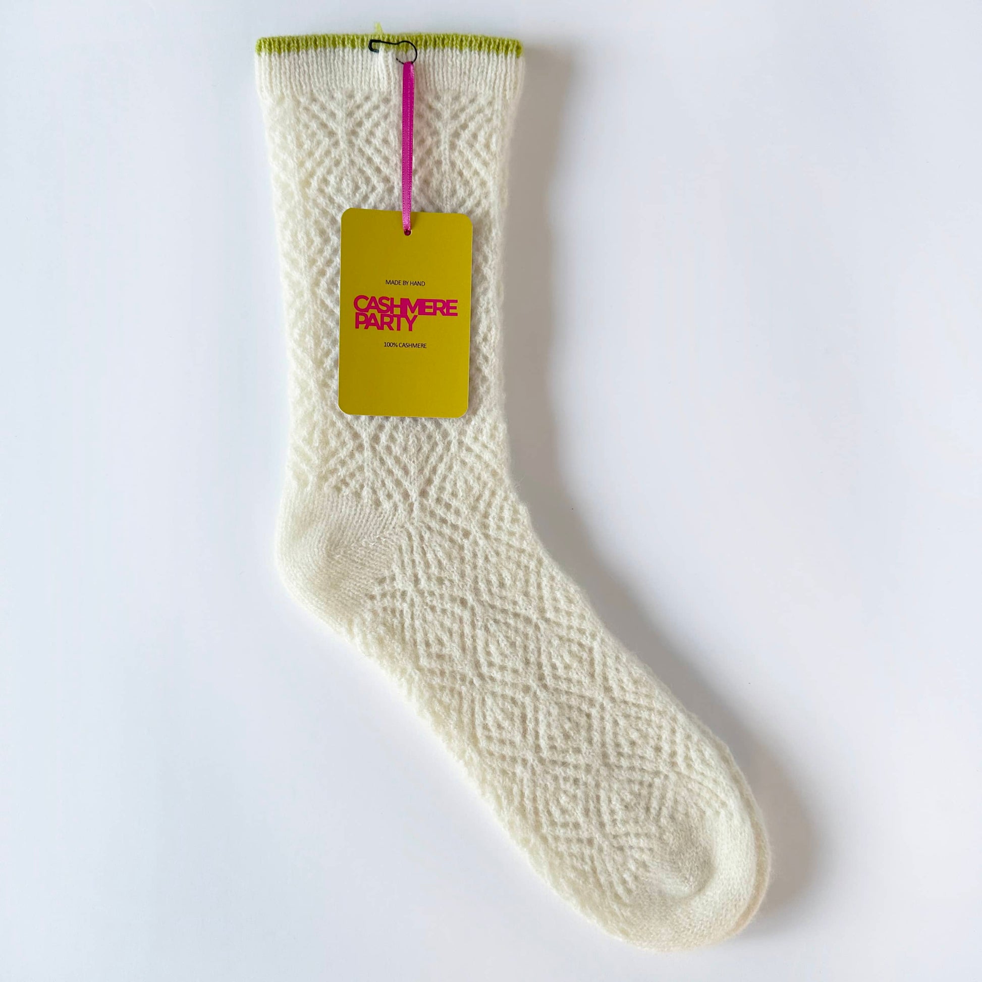 Flat image of 100% cashmere knitted lace socks by Cashmere Party.  Handmade lace knitted socks in cream cashmere with swing ticket.