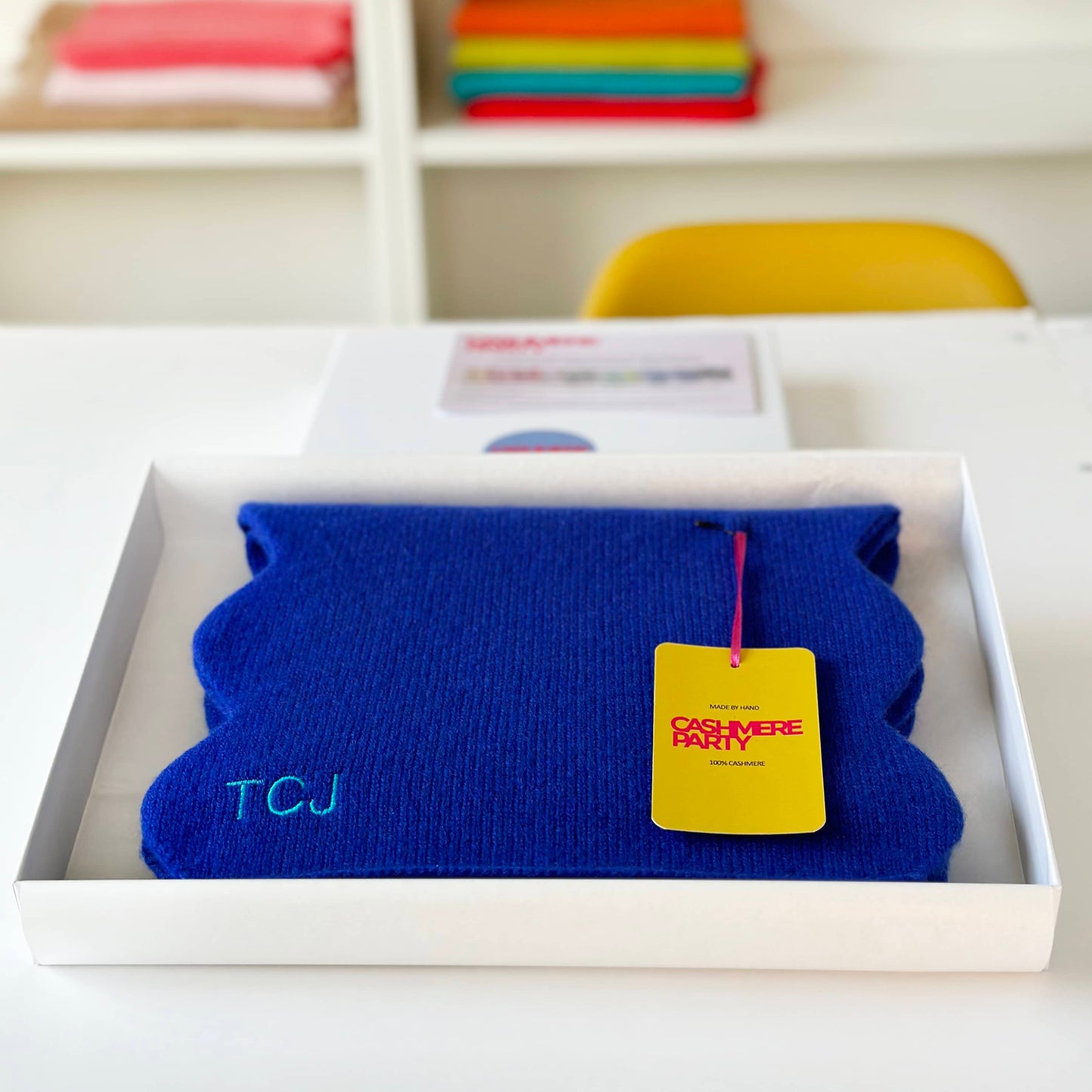 Blue cashmere scarf with scallop edges in gift box with branded swing ticket. Personalised with embroidered initials.