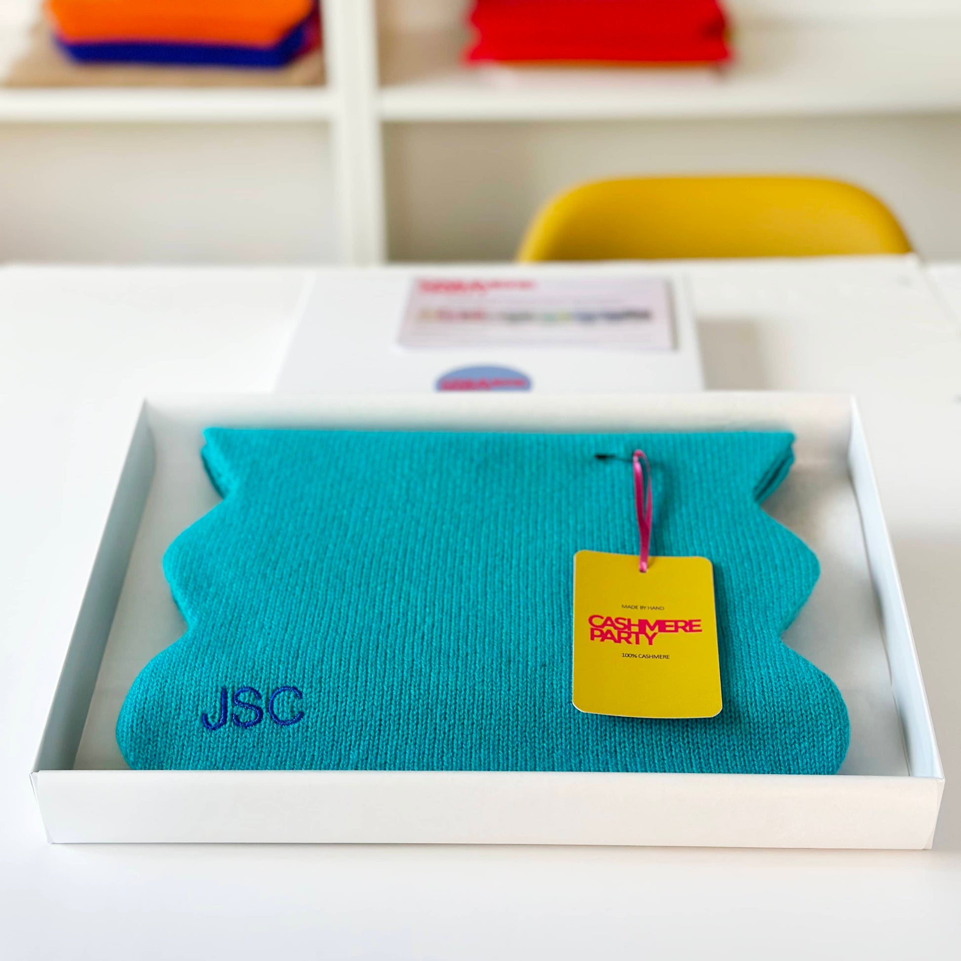 Turquoise cashmere scarf in gift box with branded swing ticket.  Handmade cashmere knitted scarf with scallop edge.  Modern fun bright cashmere scarf.