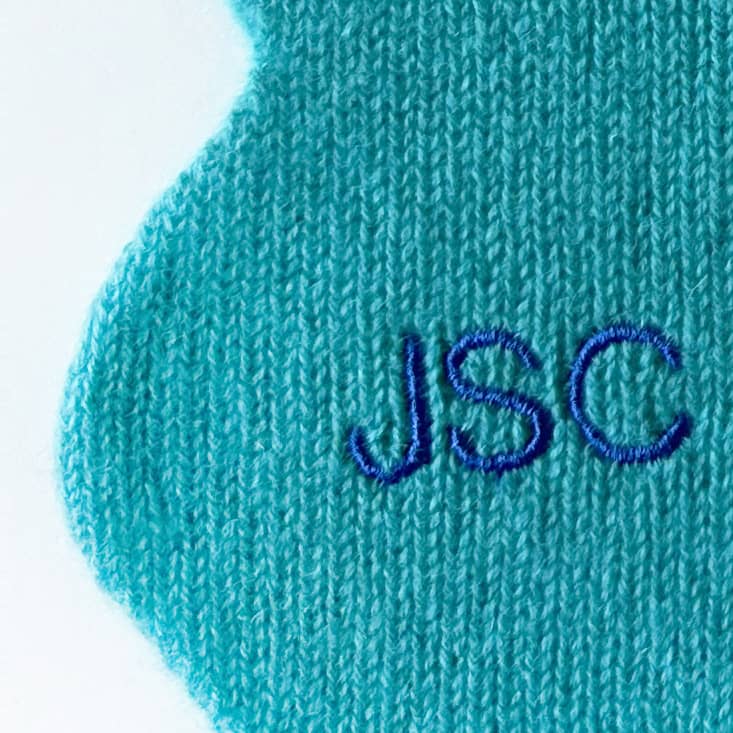 Close up of personalisation of turquoise cashmere scarf.