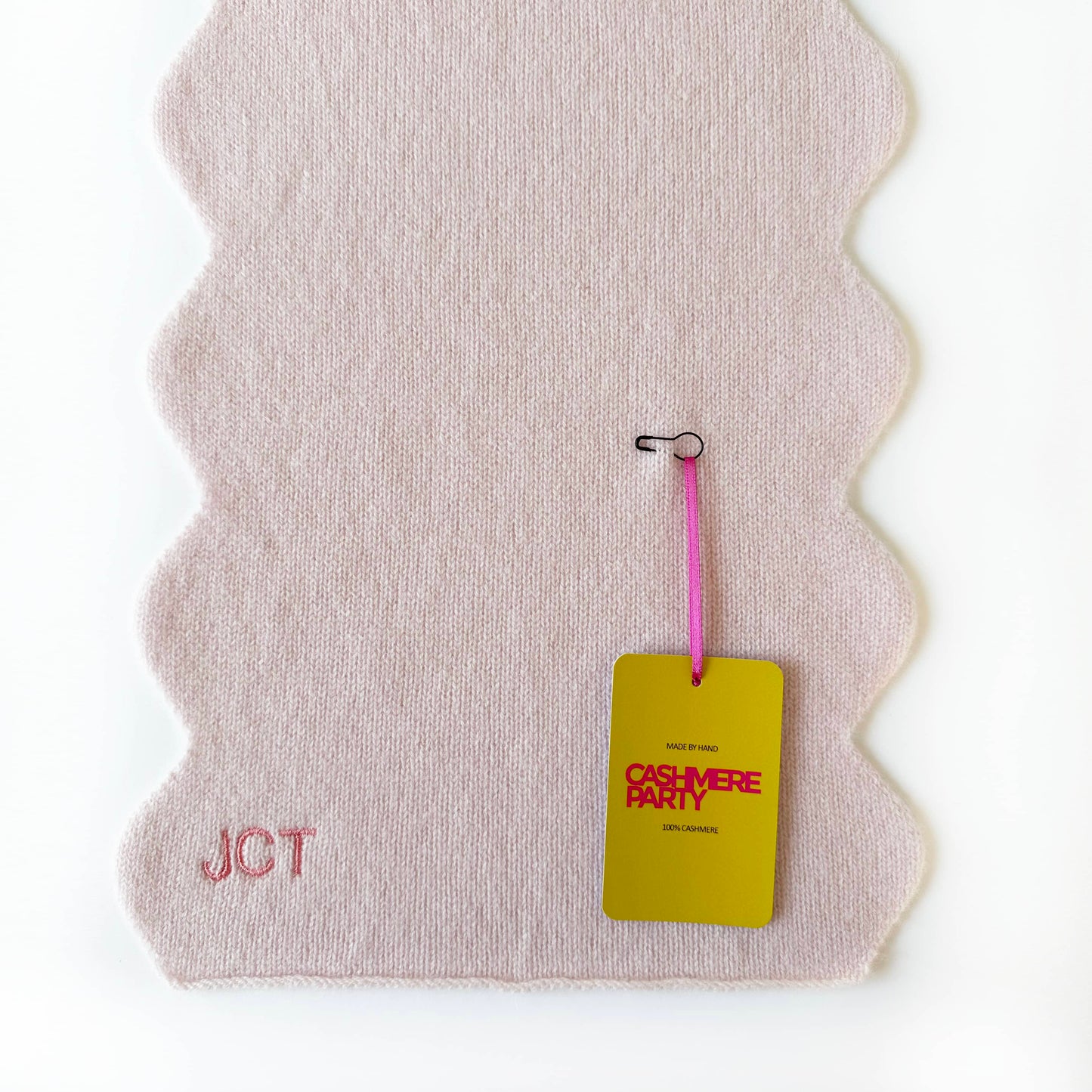 Knitted cashmere scarf by Cashmere Party with swing ticket.  Scallop edge modern fun luxury scarf gift.