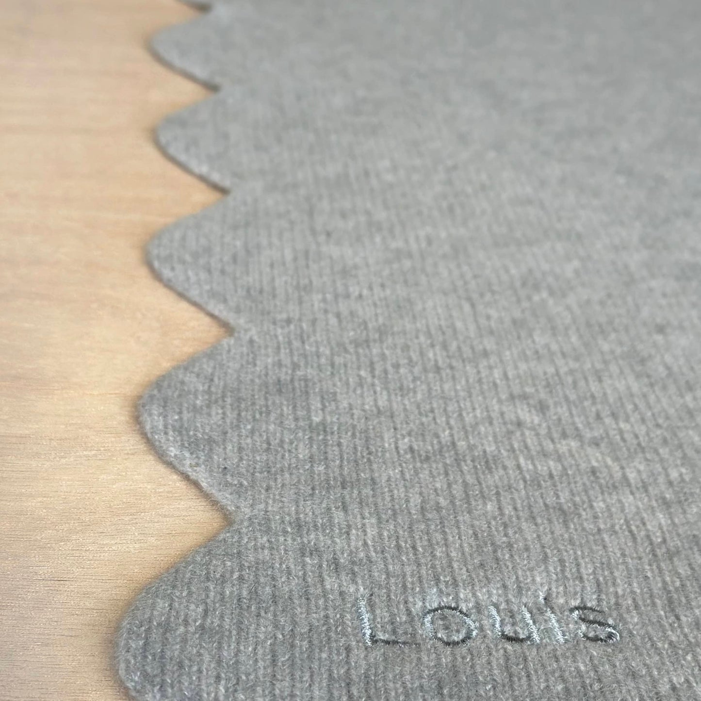 Close up of scallop edge and personalisation of cashmere baby blanket. New baby gift blanket in pure cashmere.