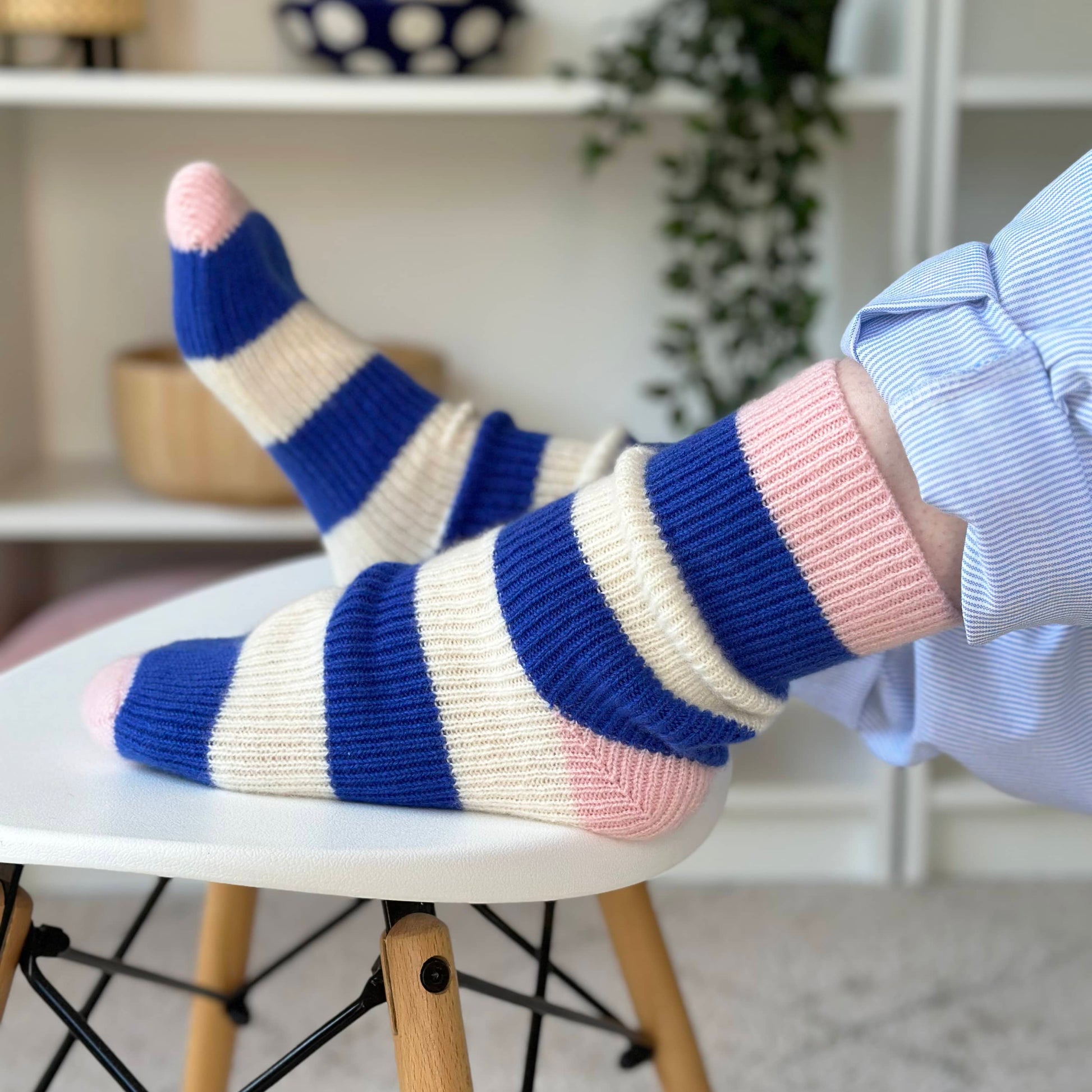 100% cashmere socks handmade stripe socks on feet up on stool.  Blue and cream stripe cashmere socks.  Pink rib and heel stripe cashmere socks.  Chunky fun socks.