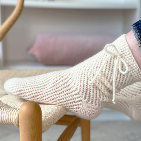 100% cashmere socks by Cashmere Party.  Mesh lace knitted handmade sock with bow detail on ankle.  Luxury knitted lace socks.