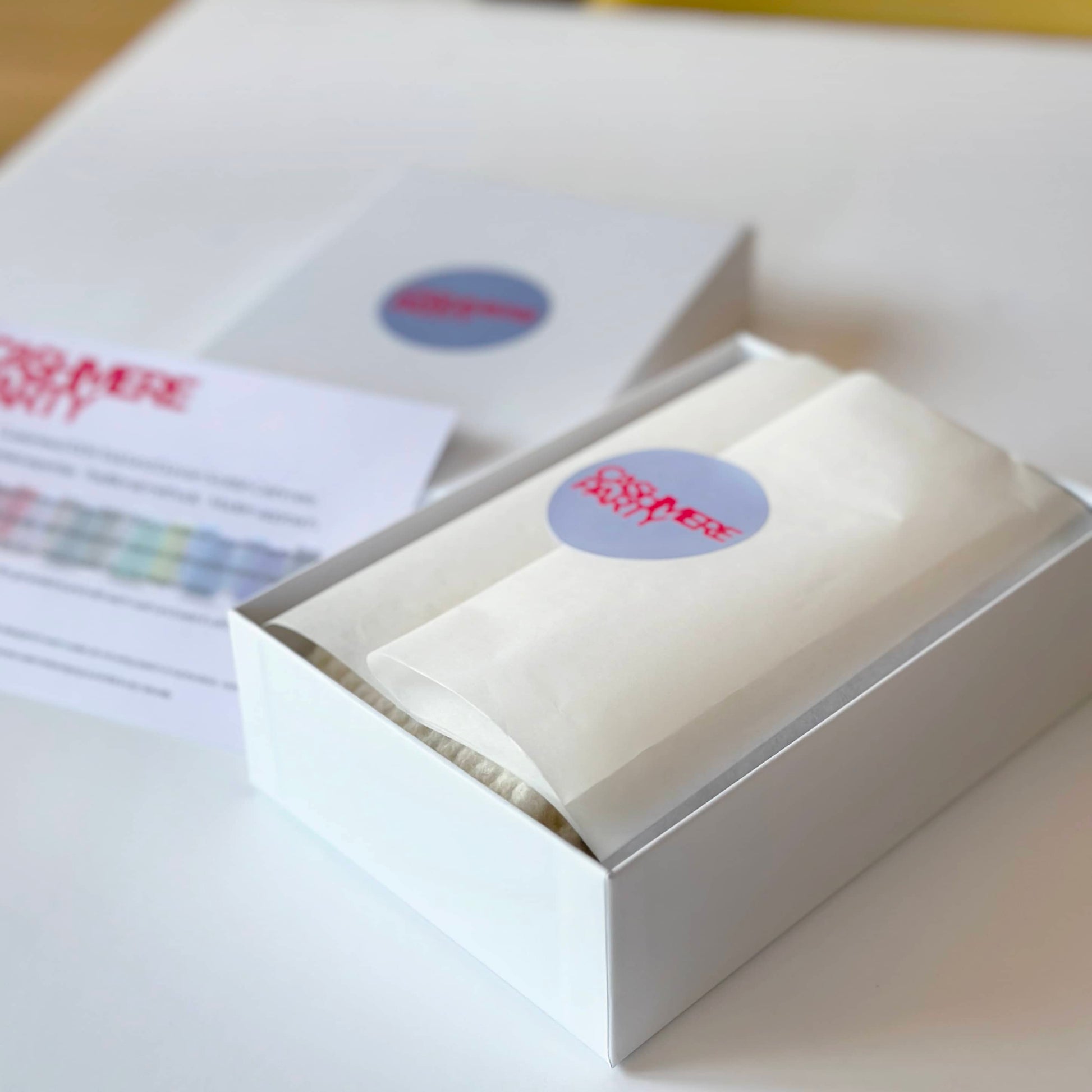 Gift box for 100% cashmere socks by Cashmere Party.  Handmade socks wrapped in tissue with a branded sticker.