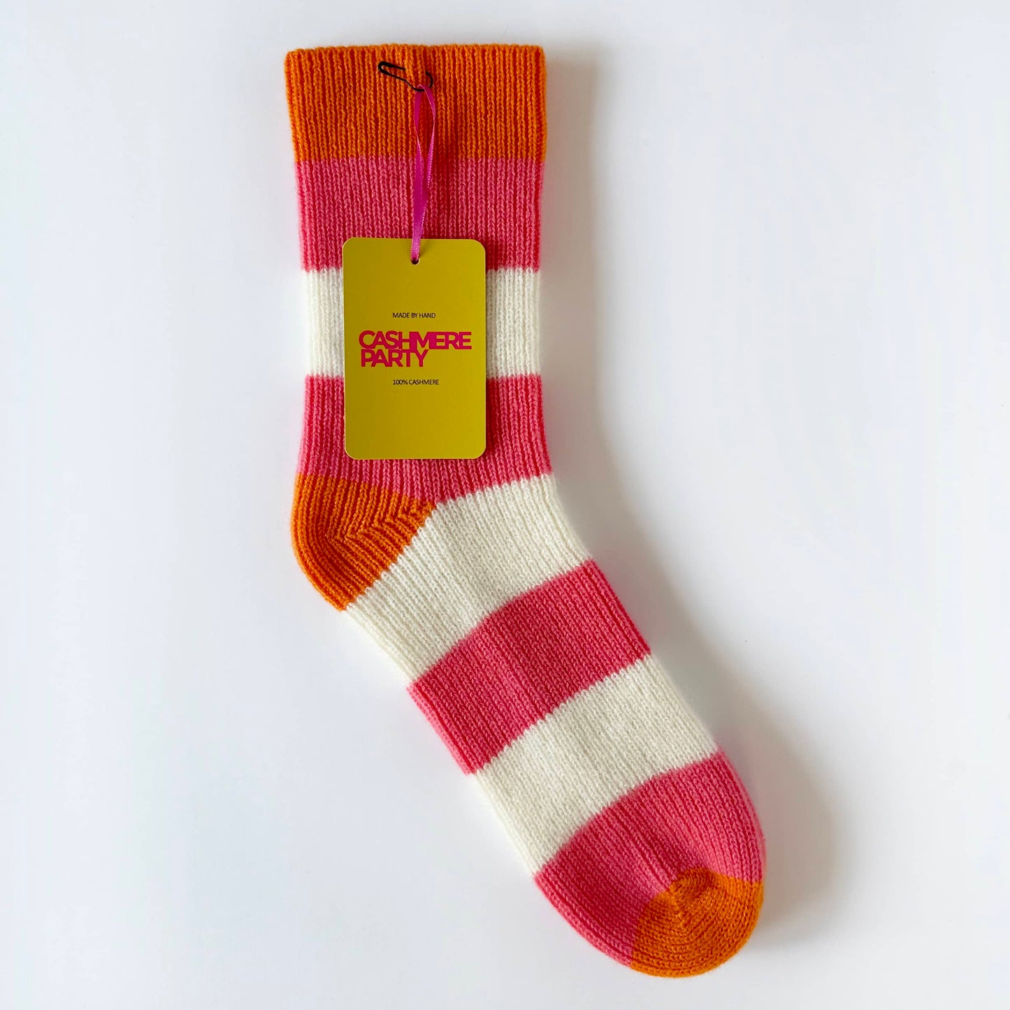 Flat image of 100% cashmere socks by Cashmere Party.  Handmade socks with bold bright stripes in coral and cream and orange colours.  With branded swing ticket.