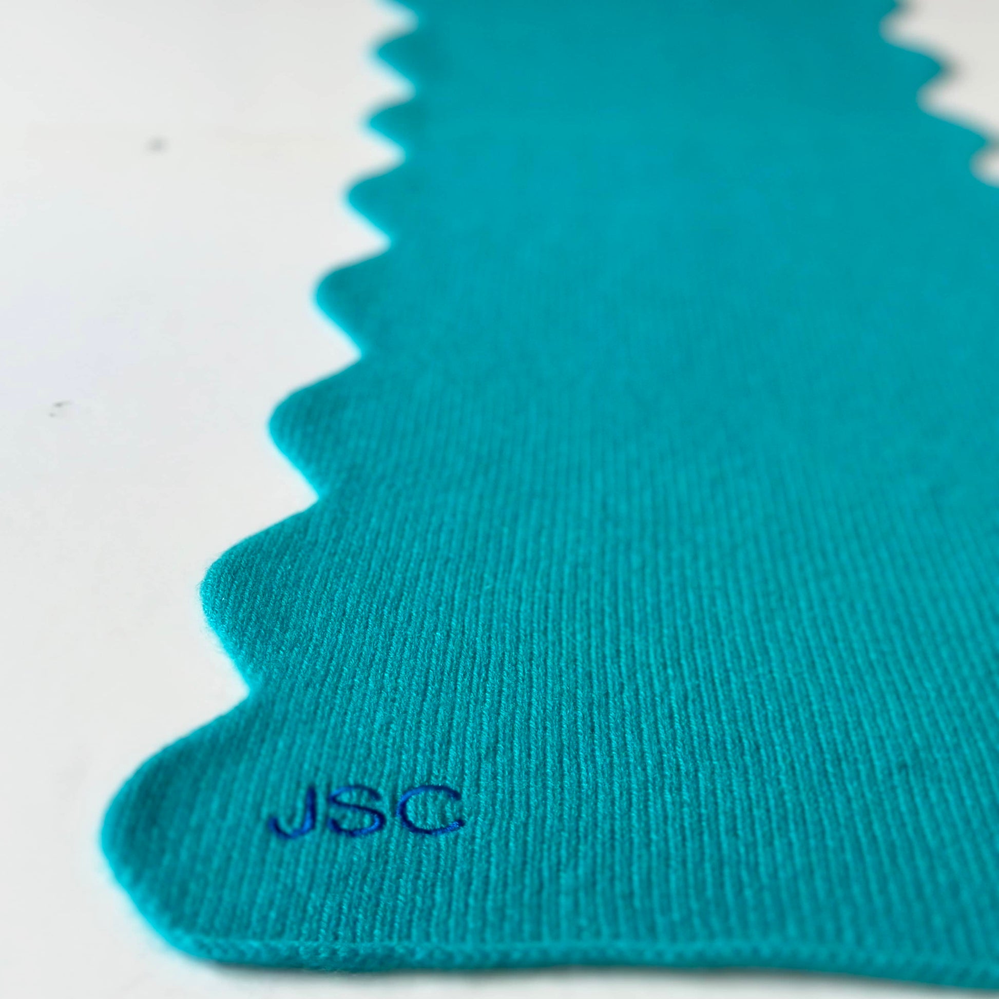 Turquoise cashmere scarf with scallop edge and embroidered personalisation.