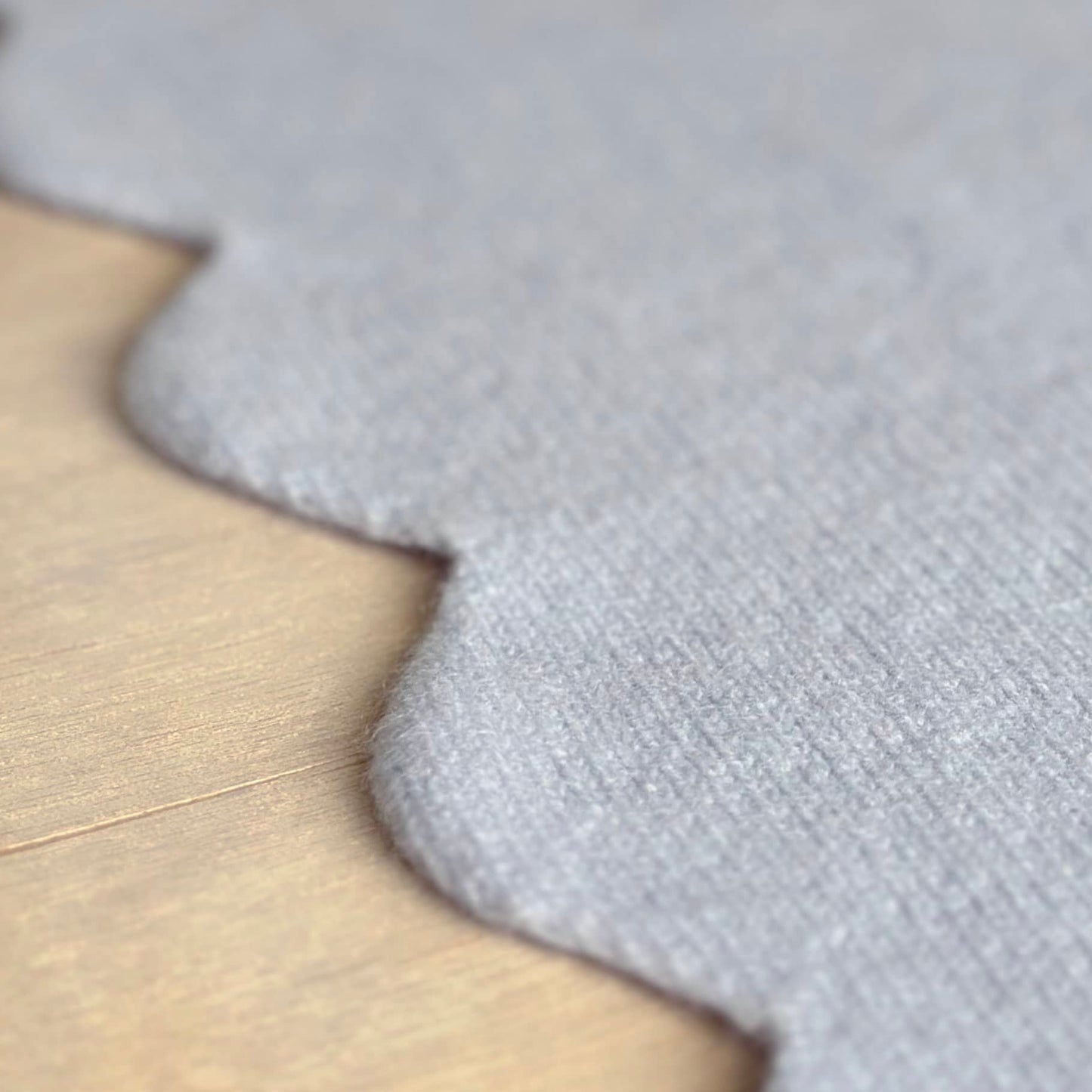 Close up of scalloped edge details of baby blanket in pure cashmere.