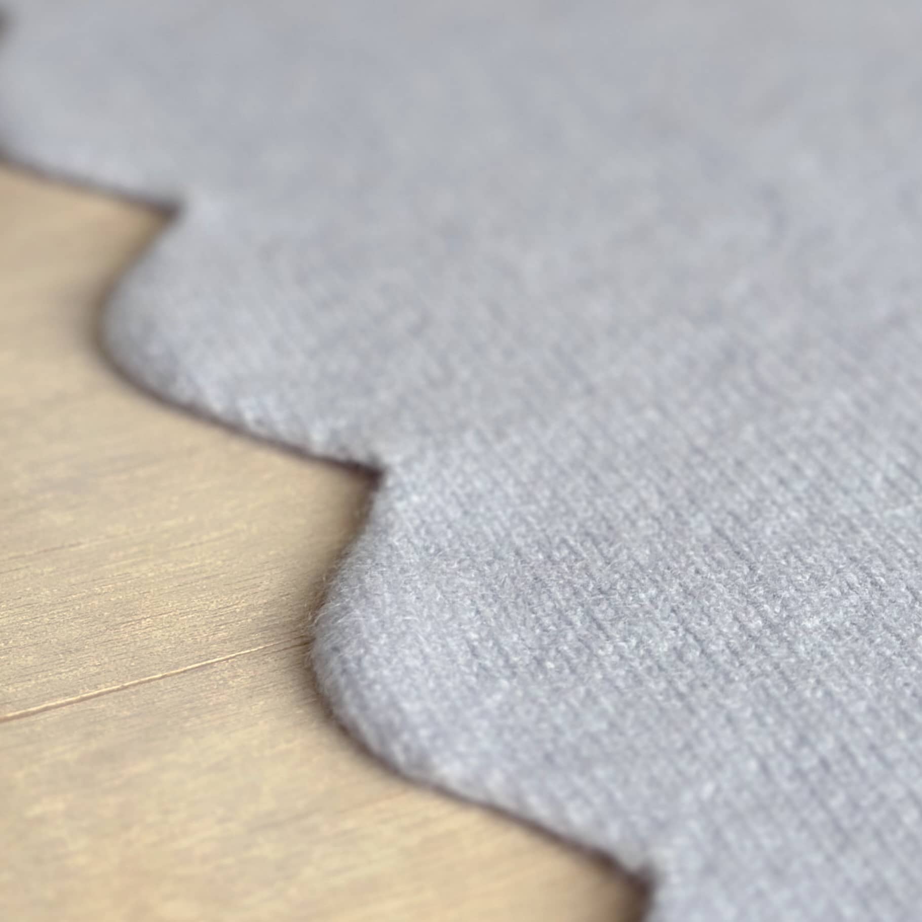 Close up of scalloped edge details of baby blanket in pure cashmere.